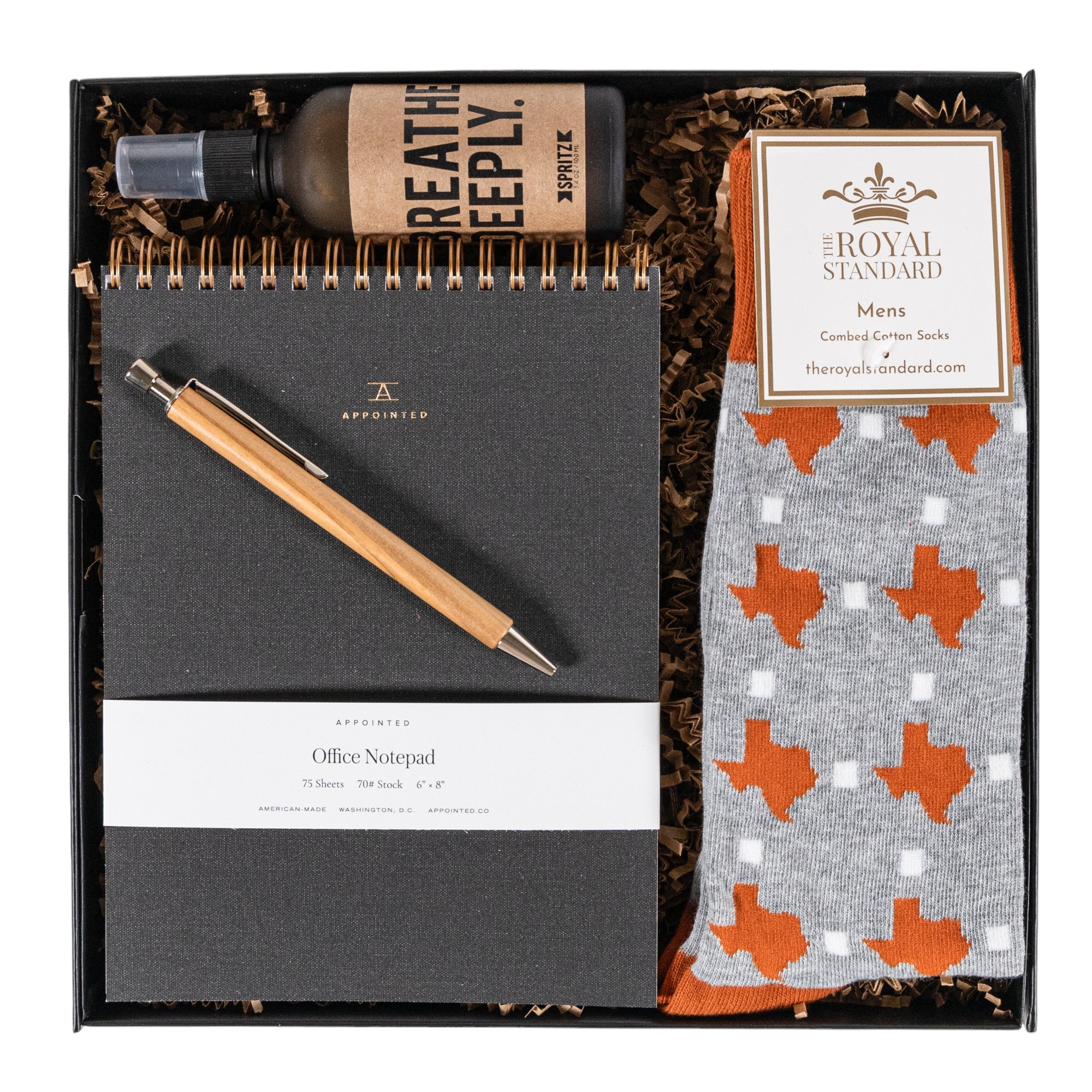 Corporate gift box featuring Texas socks, olive wood pen, office notepad, and custom note card.